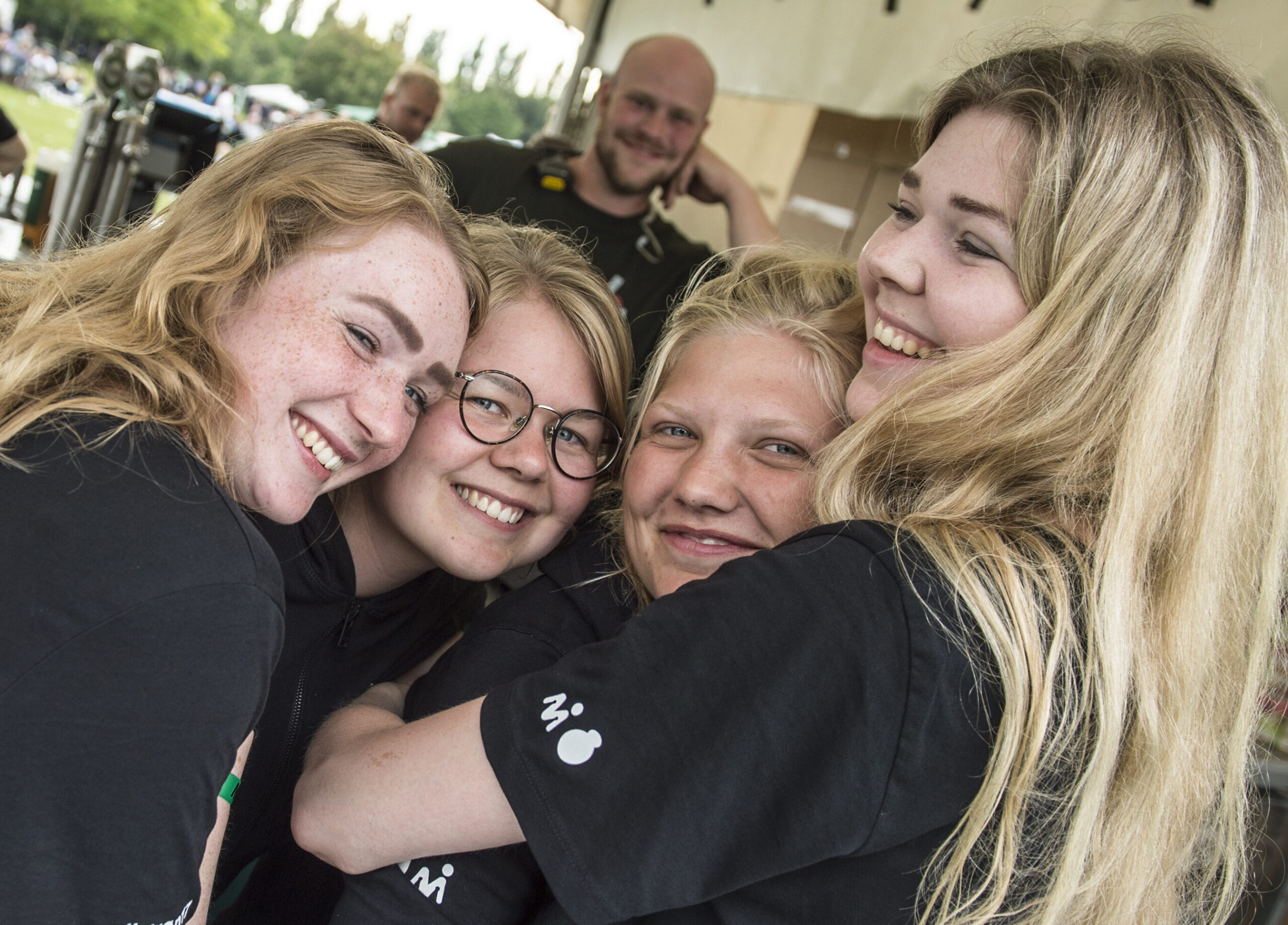Billede af fem frivillige på Grøn, der krammer og smiler til kameraet.